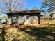 View of the backyard with a gray brick building, lawn equipment, and a gated truck bed at 3807 Woodlawn St, Sharon, SC 29742