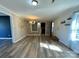 Open-concept living space with decorative accent wall, modern lighting fixture, and wood-look flooring at 3807 Woodlawn St, Sharon, SC 29742