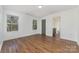 Bright bedroom featuring hardwood floors, two windows, and a gray door to an ensuite bathroom at 42 Magnolia St, York, SC 29745