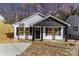 Charming home with white siding, black accents, and inviting front porch with well-lit entry for curb appeal at 42 Magnolia St, York, SC 29745