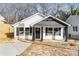 Charming home with white siding, black accents, and inviting front porch with well-lit entry for curb appeal at 42 Magnolia St, York, SC 29745