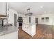Open kitchen featuring white cabinets, stainless appliances, and a granite island near the living room at 42 Magnolia St, York, SC 29745