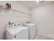 A well-lit laundry room showcases white washer, dryer, and a wire shelf for storage at 428 Nixon Rd, Belmont, NC 28012