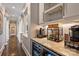 Bar area featuring wine storage, marble countertops and access to the hallway with column architecture at 4335 Piper Glen Dr, Charlotte, NC 28277