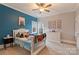 Vibrant bedroom with a blue accent wall, race car photos, and lots of stuffed animals at 4335 Piper Glen Dr, Charlotte, NC 28277
