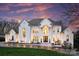 Stately white home with a symmetrical facade, arched windows, and manicured lawn under a vibrant sky at 4335 Piper Glen Dr, Charlotte, NC 28277