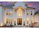 Close-up of the grand entrance with double doors, decorative columns, and elegant lighting at 4335 Piper Glen Dr, Charlotte, NC 28277