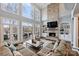 Open concept living room with large windows, fireplace, built-in shelves, and access to an outdoor patio at 4335 Piper Glen Dr, Charlotte, NC 28277