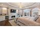 Luxurious main bedroom with a fireplace, built-in shelves, and access to a private balcony at 4335 Piper Glen Dr, Charlotte, NC 28277