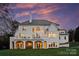 Elegant home featuring a large terrace and multiple windows against a vibrant sunset backdrop at 4335 Piper Glen Dr, Charlotte, NC 28277