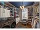 Custom walk-in closet with a front-load washer and dryer, chair, and lots of shoe and clothing storage at 4335 Piper Glen Dr, Charlotte, NC 28277