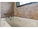 Close up of the bathtub with tile surround and a mounted shower fixture at 4914 Ridgeley Dr, Charlotte, NC 28208