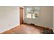 Empty bedroom featuring hardwood flooring, a window providing natural light and neutral wall color at 4914 Ridgeley Dr, Charlotte, NC 28208