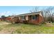Quaint brick home featuring green lawn and mature trees in a quiet neighborhood at 4914 Ridgeley Dr, Charlotte, NC 28208
