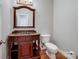 A half bathroom featuring a wooden vanity with granite countertop, wooden floors and a white toilet at 501 Colonels Ct, Clover, SC 29710