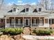 Charming brick home with a welcoming front porch, white columns, black shutters, and well-manicured landscaping at 501 Colonels Ct, Clover, SC 29710