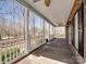 Covered front porch showcasing brick accents, ceiling fans, white railing and views of a wooded area at 501 Colonels Ct, Clover, SC 29710