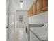 A bright laundry room with white tile floors, cabinetry above the washer and dryer and natural light at 501 Colonels Ct, Clover, SC 29710