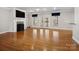 Open living room with hardwood floors, a fireplace, and a double door entrance to the backyard at 501 Colonels Ct, Clover, SC 29710