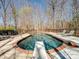 A private backyard swimming pool with a diving board, surrounded by patio furniture and landscaping at 501 Colonels Ct, Clover, SC 29710