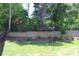 A well-maintained backyard with retaining wall, grass, and a black fence for added privacy at 5056 Blue Serenity Ct, Denver, NC 28037