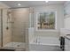 Bright bathroom with a glass enclosed shower, soaking tub, and large window offering natural light and views at 5056 Blue Serenity Ct, Denver, NC 28037