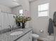 Bathroom features granite countertops, neutral walls, white cabinets, and decorative flowers at 5056 Blue Serenity Ct, Denver, NC 28037