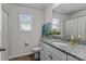 Well-lit bathroom featuring granite vanity top, a shower with curtain, and a window providing natural light at 5056 Blue Serenity Ct, Denver, NC 28037