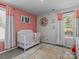 Bedroom with a white crib, decorative accents, and natural light creating a cheerful and inviting space at 5056 Blue Serenity Ct, Denver, NC 28037
