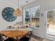 Cozy dining area with round table, modern lighting, and backyard view through a bright window at 5056 Blue Serenity Ct, Denver, NC 28037