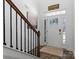 Welcoming entryway with hardwood floors, a wooden staircase, and natural light streaming through the front door at 5056 Blue Serenity Ct, Denver, NC 28037