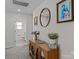 Neutral hallway with wood cabinet, decorative flowers, framed art, and open doorway to a bathroom at 5056 Blue Serenity Ct, Denver, NC 28037