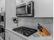 Close up of modern kitchen appliances including cooktop, microwave, and knife block at 5056 Blue Serenity Ct, Denver, NC 28037