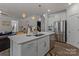 Stylish kitchen island featuring a sink, stainless steel appliances, and seamless connection to the living room at 5056 Blue Serenity Ct, Denver, NC 28037