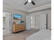Spacious main bedroom with ensuite bathroom, wood dresser, television, and neutral carpet at 5056 Blue Serenity Ct, Denver, NC 28037