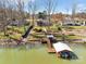 Stunning aerial view of waterfront homes, landscaped yards, and a private boat dock on a serene lake setting at 5064 Lynwood Rd, Sherrills Ford, NC 28673