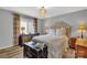 Cozy bedroom featuring patterned drapes, wood floors, and a soft, upholstered headboard at 5064 Lynwood Rd, Sherrills Ford, NC 28673