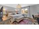 Well-lit bedroom with plush bedding, bench, and a large window overlooking the landscaped outdoors at 5064 Lynwood Rd, Sherrills Ford, NC 28673