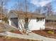Detached garage featuring a gray garage door with a blue entrance, surrounded by landscaping at 5064 Lynwood Rd, Sherrills Ford, NC 28673