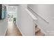 Bright hallway with carpeted stairs, white walls, wooden floors and decorative artwork at 537 Trading Post Ln, York, SC 29745