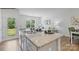 Modern kitchen with a granite island, stainless steel sink, and views into the living area at 537 Trading Post Ln, York, SC 29745