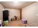 View of the carpeted basement featuring a door, storage containers, and neutral-colored walls, perfect for storage or recreation at 5448 Bill Sain Rd, Vale, NC 28168