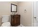 Powder room with tile floors and a wooden vanity, alongside a standard toilet at 601 Highland Forest Dr, Charlotte, NC 28270