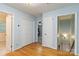 Light-filled hallway with hardwood floors and multiple doors, offering access to various parts of the home at 601 Highland Forest Dr, Charlotte, NC 28270