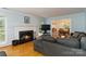 Cozy living room with a traditional fireplace, hardwood floors, and a comfortable gray sofa at 601 Highland Forest Dr, Charlotte, NC 28270