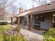 Backyard featuring a covered patio, manicured lawn, mature trees, and a decorative pond at 6200 Summertree Ln, Charlotte, NC 28226