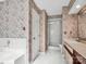 Bathroom showcasing floral wallpaper, a glass shower, and white tiled flooring for a clean look at 6200 Summertree Ln, Charlotte, NC 28226
