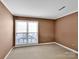 A bright bedroom with a large window and neutral decor at 6200 Summertree Ln, Charlotte, NC 28226