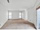Spacious living room featuring neutral carpeting, white walls, and plenty of natural light at 6200 Summertree Ln, Charlotte, NC 28226