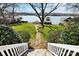 Lush backyard leading to a tranquil lake, featuring a stone pathway and manicured landscaping at 6403 Amos Smith Rd, Charlotte, NC 28214